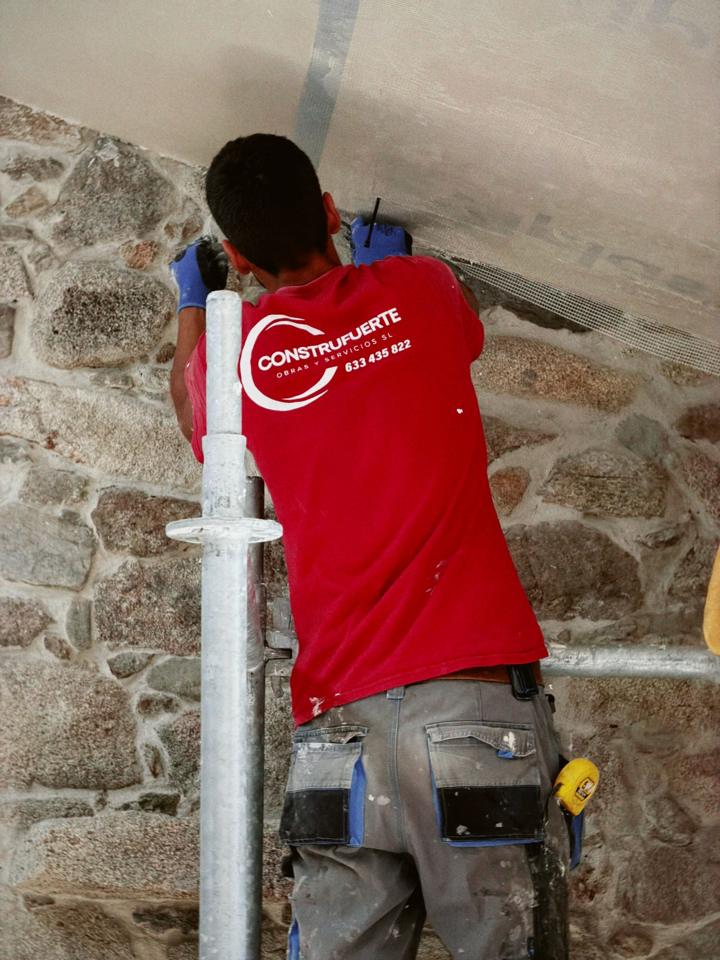 Operario de Construfuerte trabajando desde un andamio interior — obra de Construfuerte